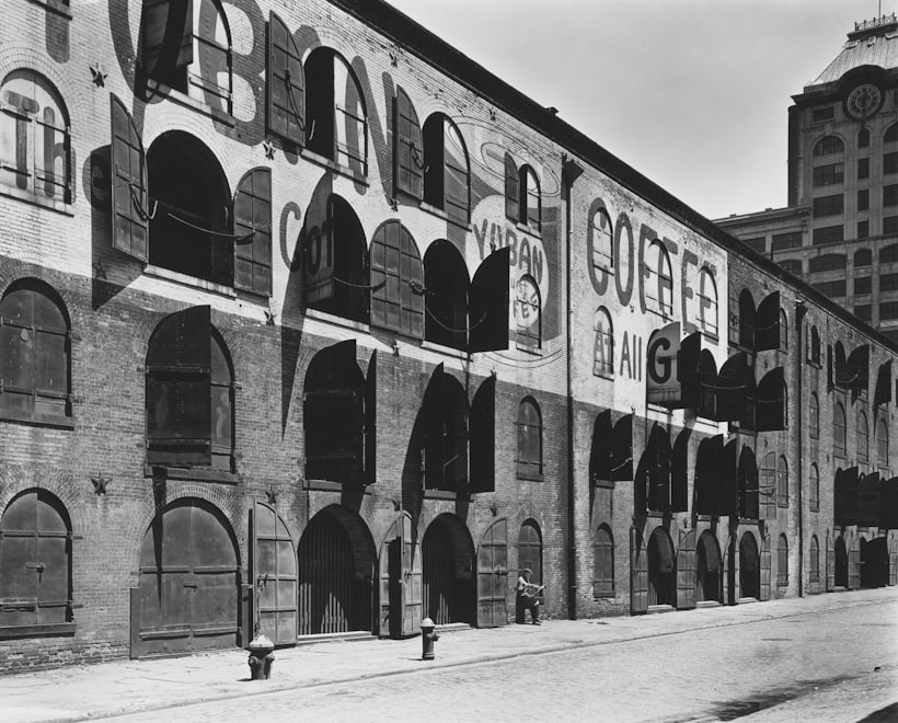 A brick bonded warehouse with arched windows and loading doors